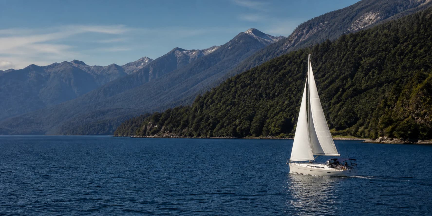 Velero navegando el lago Nahuel Huapi frente a las montañas de Bariloche